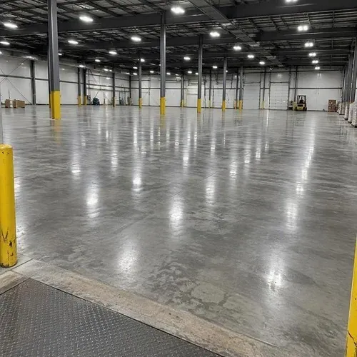 Freshly sealed concrete floor in empty warehouse after commercial flooring installation