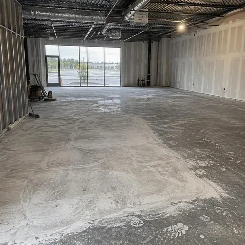 Ground concrete prepped for flooring in storefront during commercial flooring installation