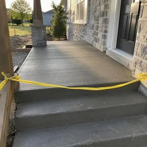 Broom-finished concrete porch slab, freshly poured after concrete floor installation