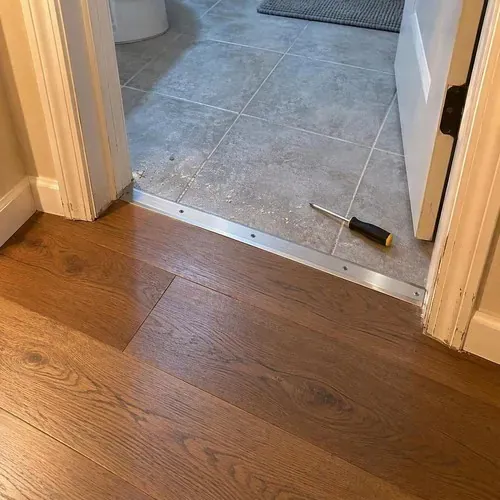 Engineered hardwood meeting tile at doorway threshold during engineered hardwood installation