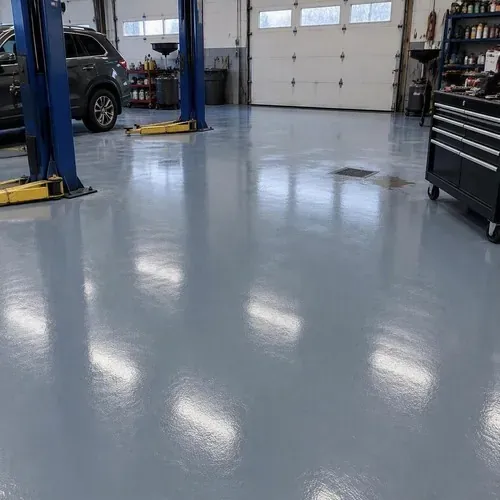 Finished blue-gray epoxy floor in auto shop after epoxy floor installation
