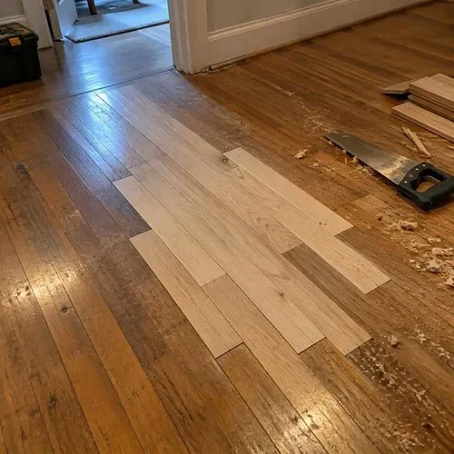 New boards woven into old hardwood floor during floor and subfloor repair