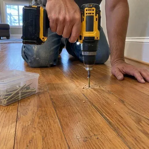 Squeaky floor repair screws driven into hardwood during floor and subfloor repair