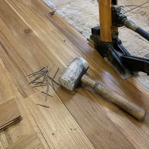 Close-up of cleat nails and flooring mallet used in hardwood floor installation