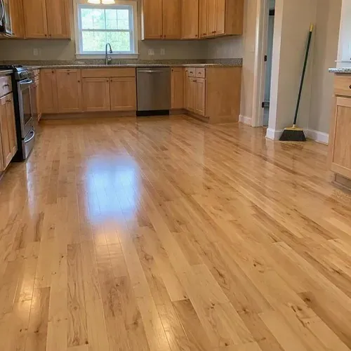 Finished natural maple floor in empty kitchen after hardwood floor installation