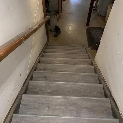 Basement stairs with new vinyl stair treads after stair and railing installation