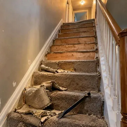 Old carpet torn off staircase exposing treads before stair and railing installation