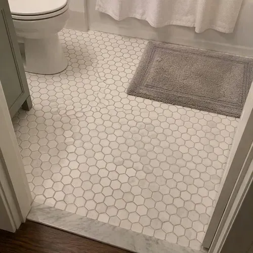 Finished white hexagon mosaic bathroom floor tile after ceramic and porcelain tile installation