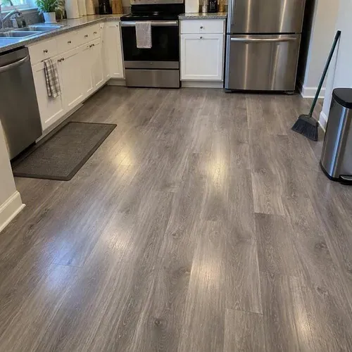 Finished gray vinyl plank floor in kitchen after vinyl and laminate flooring installation