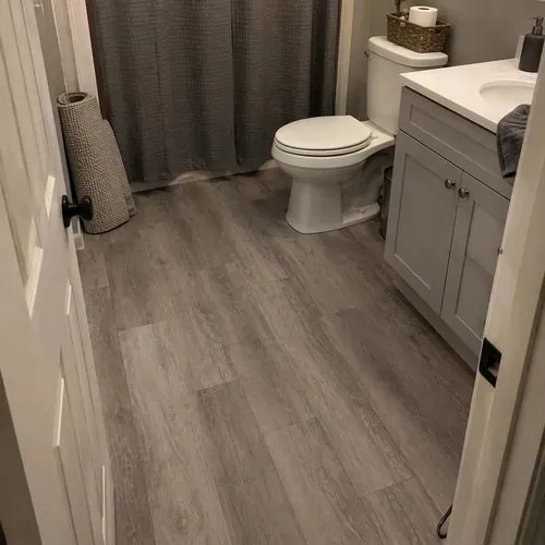 Finished luxury vinyl planks in basement bathroom after vinyl and laminate flooring installation