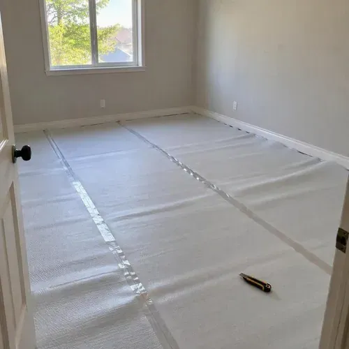 Foam underlayment with taped seams in bedroom during vinyl and laminate flooring installation